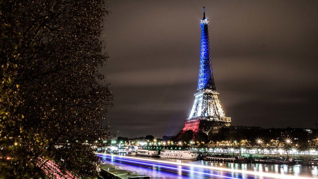 The Eiffel Tower lit in blue white red - Fluctuat nec Mergitur